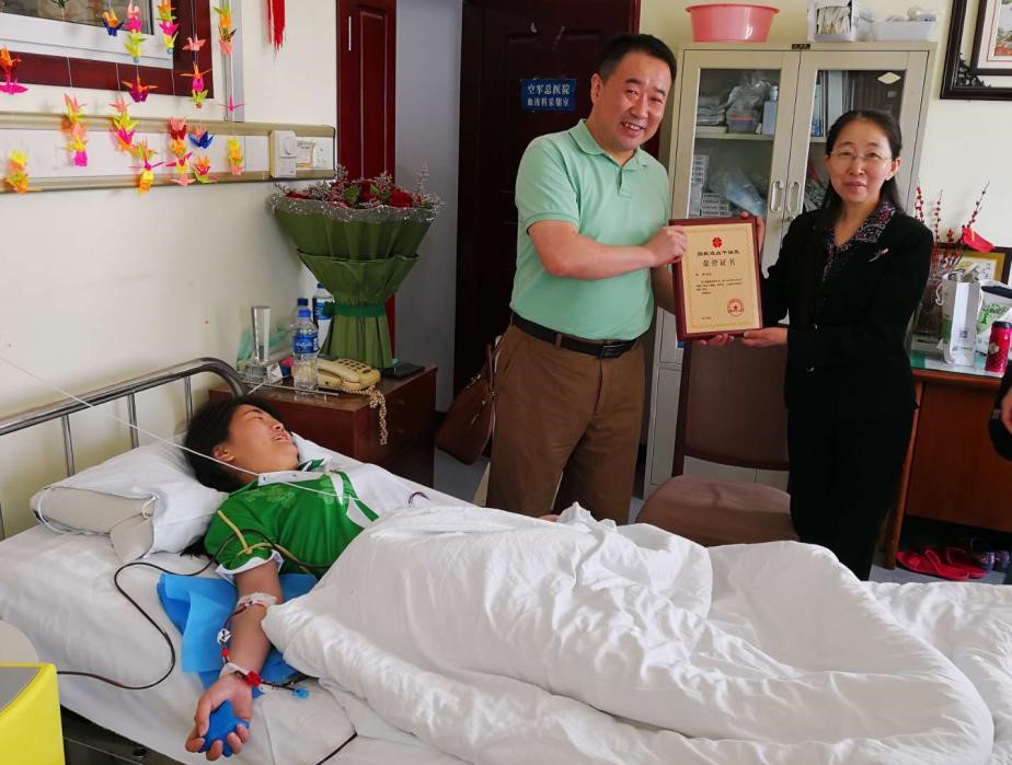 中华骨髓库北京分库的主任梁永清先生为肖瑛颁发志愿者奖牌及证书.jpg